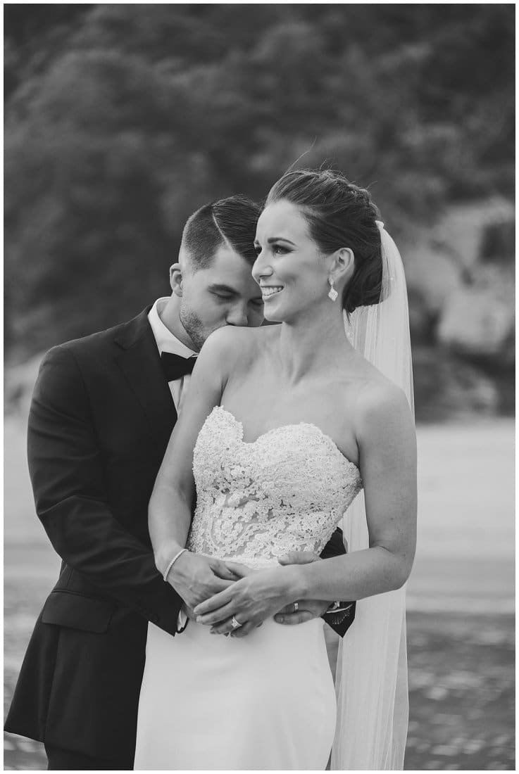 black and white photo of bride and groom hugging
