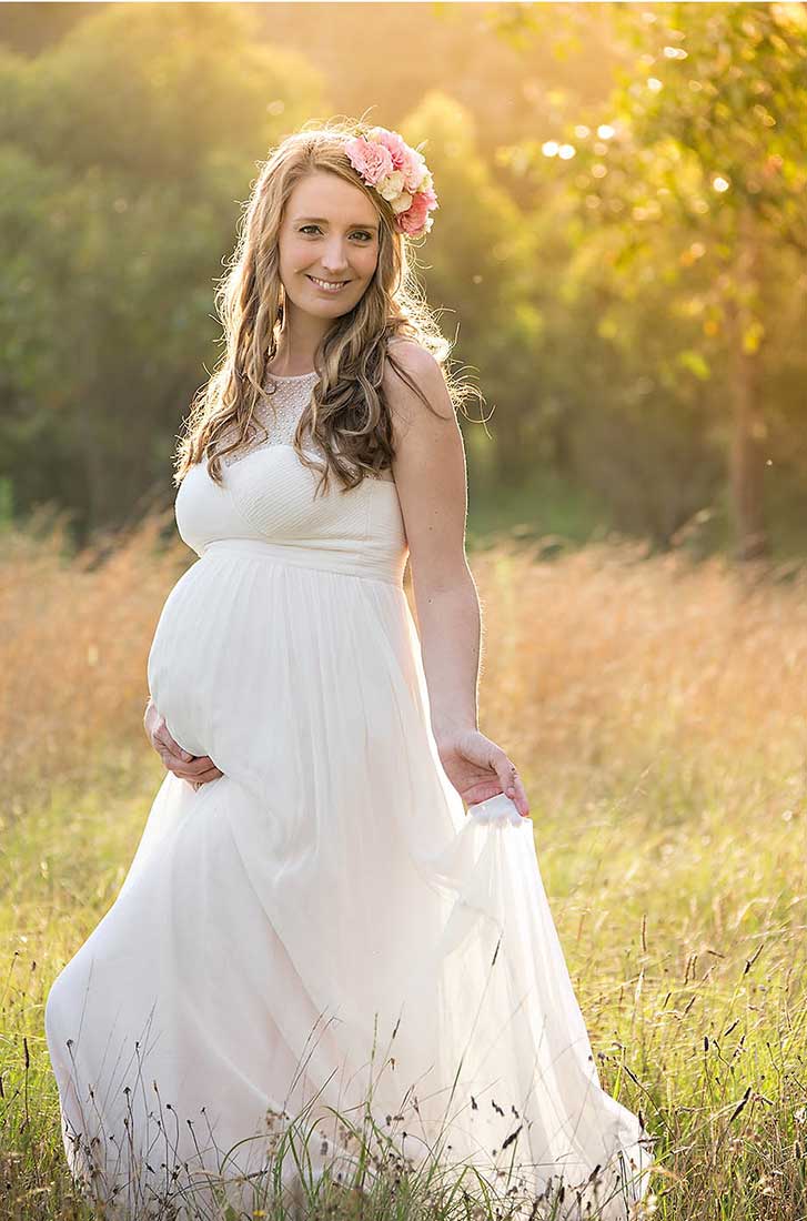 maternity photo in a field at sunset
