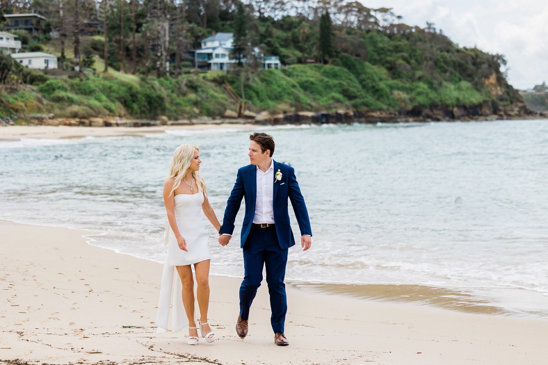 bride and groom walking along the beach norah head